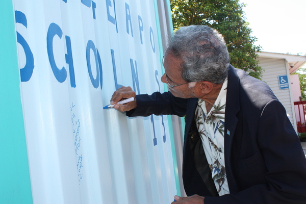 Ambassador Winston Thompson signs the solar-powered computer lab.