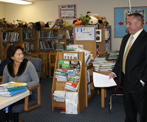 Charles Russo, the superintendent of East Moriches School District, reads a letter; Remsenburg/Speonk Superintendent Katherine Salomone listens on at the school district's board of education meeting. JESSICA DINAPOLI