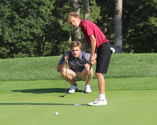 East Hampton's Turner Foster, and his teammate Nate Wright, watch his putt. KYRIL BROMLEY