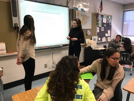 Paula González, pictured left, helps students in Sarah Trujillo Underhill's 11th grade class at Southampton High School. COURTESY MARY JANE GREENFIELD