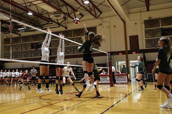 Westhampton Beach senior Cortina Green tries to tip the ball over the net and over East Hampton's Elle Johnson and Mary McDonald. KYRIL BROMLEY