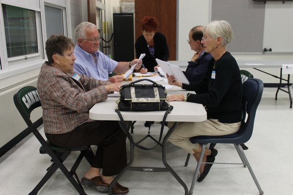 Absentee ballots are counted up inside the Westhampton Beach High School polling area Tuesday night. KYLE CAMPBELL