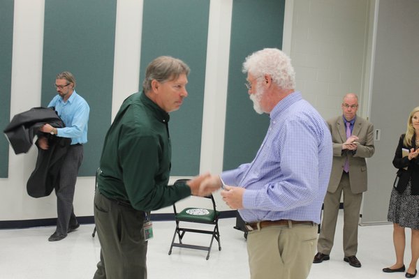 Westhampton Beach Board of Education candidates Stephen Wisnoski, left, and Jim Hulme shake hands after Mr. Hulme is announced the winner Tuesday night. KYLE CAMPBELL