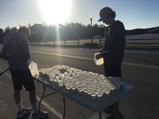 Volunteers get set at one of the water stops along the route of the Hamptons Marathon races. MICHELLE MALONE