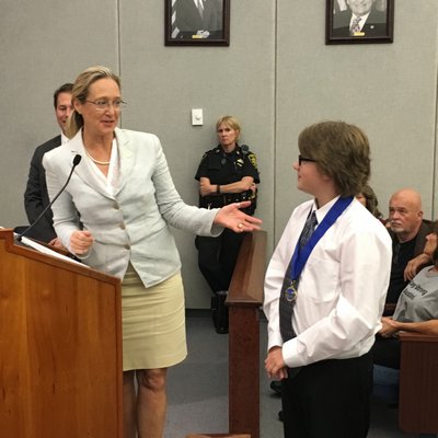 Suffolk County Legislator Bridget Fleming presents Daniel Stark with a proclamation for his work on his project.   COURTESY ROBERT LONG