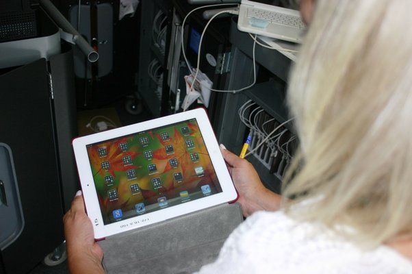 Quogue School librarian Dawn Hine uses one of the school district's Apple iPads. The 20 iPads recently acquired by the school bring the total number of tablets available to students to 80. KYLE CAMPBELL