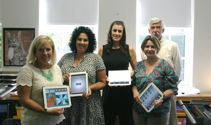 From left, Quogue School librarian Dawn Hine, special education teachers Stacey Russell and Kristina Levy, computer coordinator and teacher Colleen McGreevy and superintendent Richard Benson display some of the district's recently purchased Apple iPads. KYLE CAMPBELL