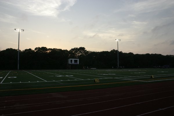 Newly installed lights illuminate the new synthetic turf football field at Hampton Bays High School during a junior varsity football game Tuesday. Both the lights and the field were part of phase one of the district's $16.8 million bond project. KYLE CAMPBELL