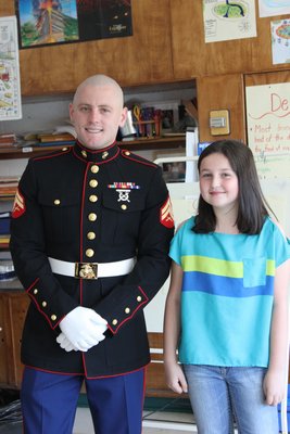 Marine Corporal Jacob Campbell with Jocelyn McNamara, 10, at the East Quogue Elementary School on Wednesday, April 24. By Carol Moran