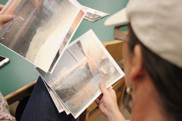 Community members review pictures of the current conditions of the school. VALERIE GORDON