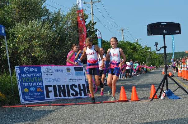 A trio of I-Tri girls cross the finish line. KIM COVELL