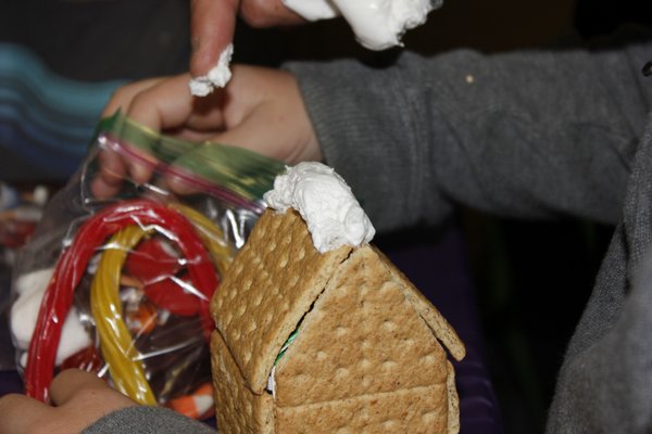 Students make gingerbread houses out of graham crackers and icing. VALERIE GORDON