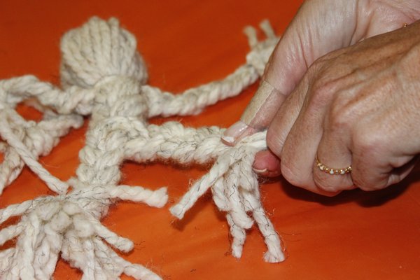 Carrie Ryan shows the students how to make yarn dolls. VALERIE GORDON