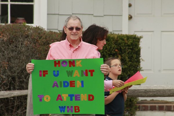 Patrick Smith of South Jamesport holds a sign advocating that his nephew, Aiden Killoran, a 12-year-old Remsenburg-Speonk student with Down Syndrome, be allowed to attend Westhampton Beach Middle School next year. KYLE CAMPBELL