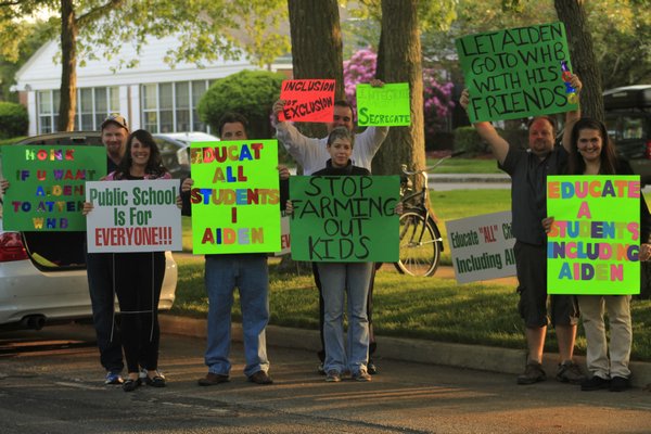 Christian and Terrie Killoran of Remsenburg orchestrated a protest outside the Remsenburg-Speonk Elementary School on Monday night prior to the school's board of education meeting. KYLE CAMPBELL