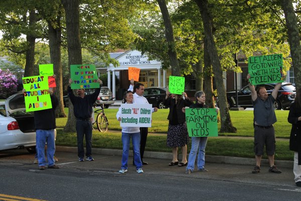 Christian and Terrie Killoran of Remsenburg orchestrated a protest outside the Remsenburg-Speonk Elementary School on Monday night prior to the school's board of education meeting. KYLE CAMPBELL