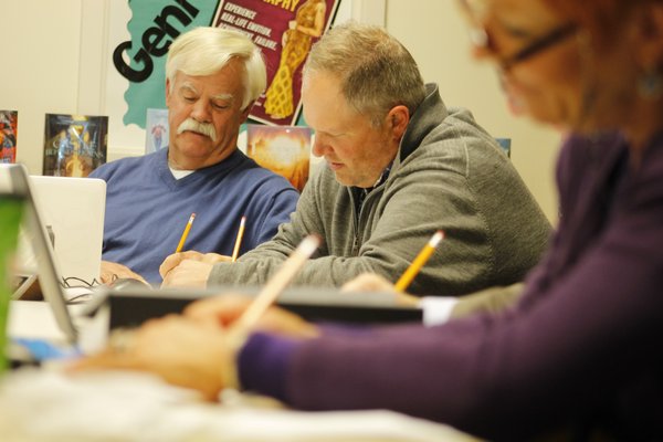 From left, Westhampton Beach Board of Education members Halsey Stevens and George Kast take an algebra "sprint" quiz during Monday night's board meeting. KYLE CAMPBELL