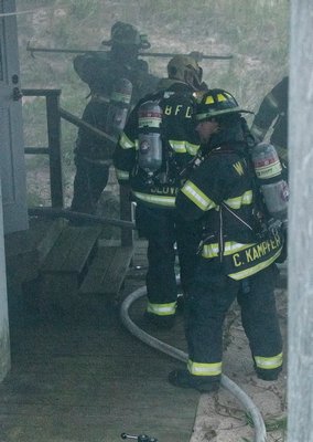 A hose team prepares to enter the basement area where the volunteers encountered fire and heavy smoke. COURTESY WESTHAMPTON BEACH FIRE DEPARTMENT