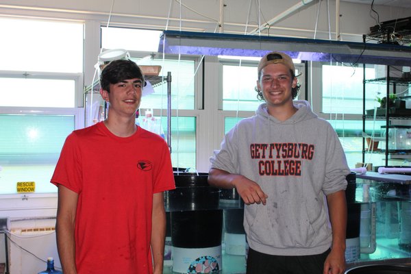 Danny and Ryan, recent Westhampton Beach High School graduates, stand in front of their final tank project for Mr. Kommer's Marine Science class. KATE RIGA
