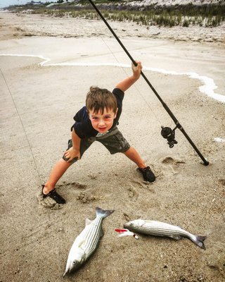 Young Mike Dean and the double header of stripers he and his dad, Michael, hauled out of the Quogue surf over the weekend. Michael Dean