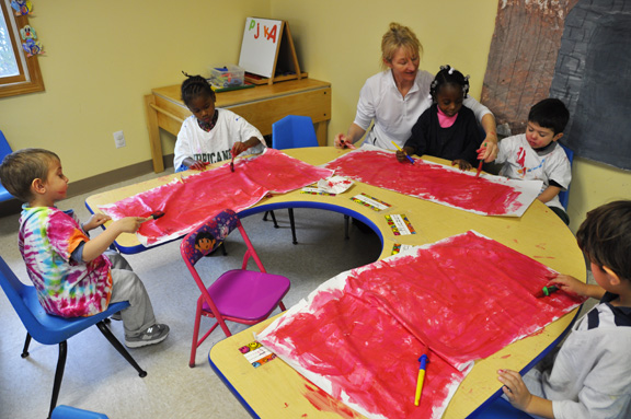 Instructor Claire Kirshy paints with a group of students in the integrated class at Side By Side Child Care in Southampton.
