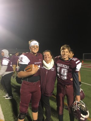 Southampton senior quarterback Shawn Stelling, left, with his younger brother, sophomore Ryan Stelling, and their mother, Dawn Stelling, after the team's win over Hampton Bays for the Mayor's Cup.