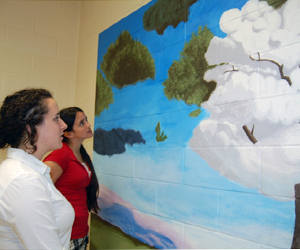 Shaileen McKenna and Elizabeth Pizzichemi view their painting, a recreation of Samy Charnine's "A Day in the Clouds."      VERA CHINESE