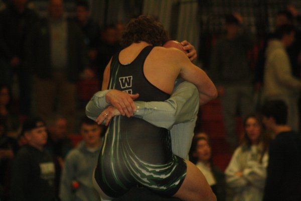 Westhampton Beach senior Liam McIntyre jumps into the arms of head coach Paul Bass after winning his second straight county title. CAILIN RILEY