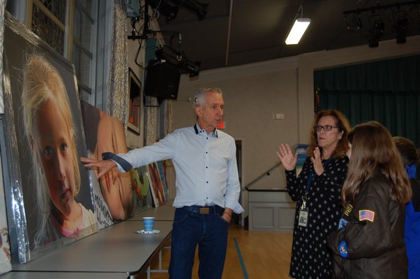 Artist Charles Wildbank showing his paintings to students and staff of Our Lady of the Hamptons Regional Catholic School. JON WINKLER