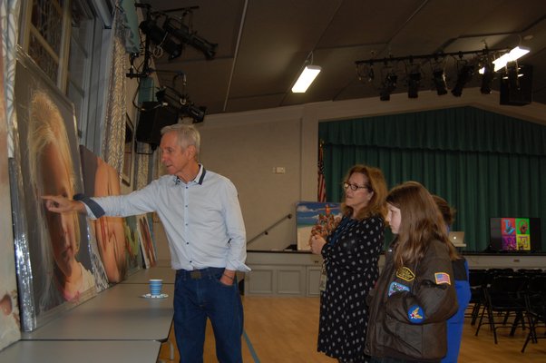 Artist Charles Wildbank showing his paintings to students and staff of Our Lady of the Hamptons Regional Catholic School. JON WINKLER