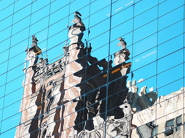 Building reflected in shiny surface of another building. MARGERY HARNICK