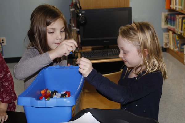 From left, first graders Aaliyah Delalla and Delilah Tunney play with magnets. KATE RIGA