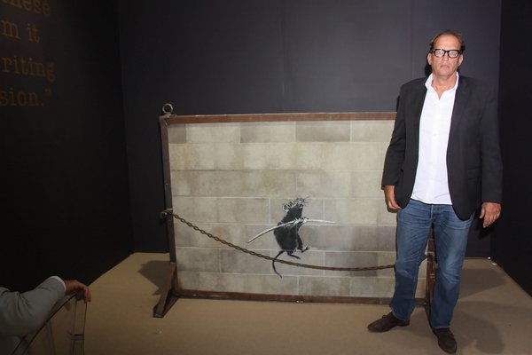 Stephan Keszler with Banksy's "Tightrope Rat." TOM KOCHIE