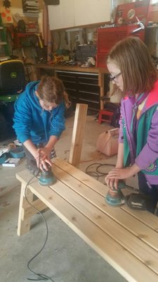 Girl Scouts Emma Sirico, left, and Jessica Curran work on building a bench for their Bronze Award project. COURTESY ABBIE DERMODY