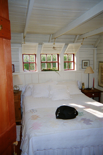 A typical Siaconset bedroom, sans large headboard, with the bed pushed right up against the low-slung sleeves.