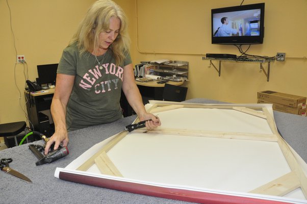 Production Manager Annie Scheuring hand-stretches a digital thermal print at Modern Digital Canvas. MICHELLE TRAURING