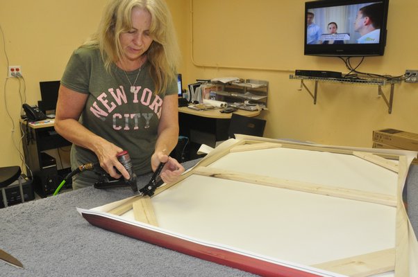 Production Manager Annie Scheuring hand-stretches a digital thermal print at Modern Digital Canvas. MICHELLE TRAURING