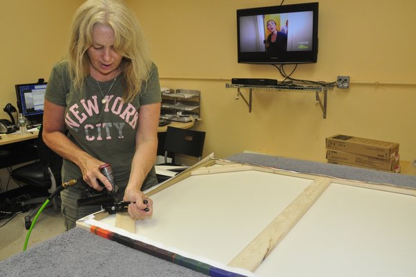 Production Manager Annie Scheuring hand-stretches a digital thermal print at Modern Digital Canvas. MICHELLE TRAURING