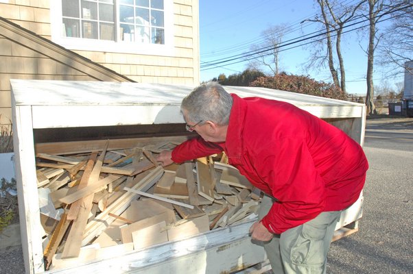 Larry O'Toole sorts through the scap pile at Deerfield Millwork in Water Mill. DANA SHAW