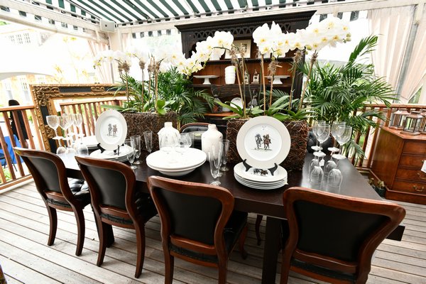 The setting including a French provencal walnut table with dark walnut hutch and French empire style chairs; accented with all white chargers, plates and white orchids. This setting, pulling together the dark woods with white accessories was classic country chic! DANA SHAW