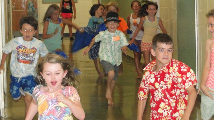 Camp Invention students race through the hallway at Springs School as part of a team-building exercise. COLLEEN REYNOLDS