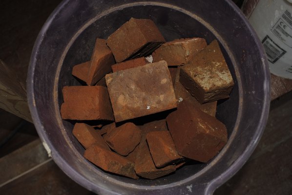 A bucket of bricks from the 1700s being used to restore a cooking oven in the Foster-Meeker Heritage Center in Westhampton Beach. AMANDA BERNOCCO