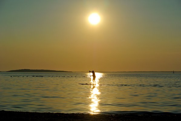 August 8: A paddleboarder heads in at sunset at Long Beach in Sag Harbor.