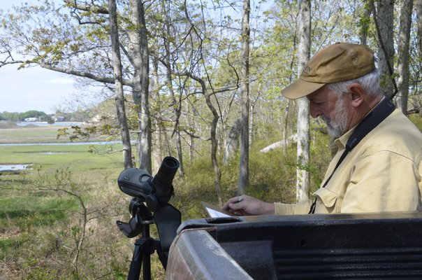 The Nature Conservancy's Preserve Manager Mike Scheibel makes a note that an osprey nest is active, after checking it out with his Swarovski scope. SHAYE WEAVER