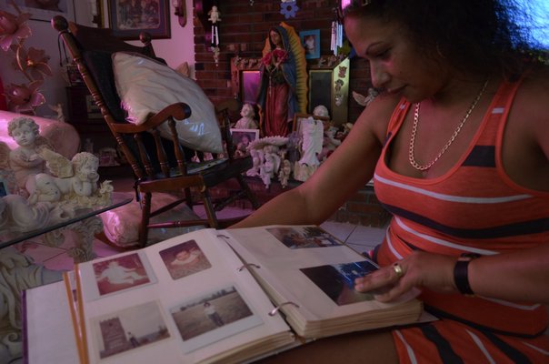 July 24 -- Veronica Cruz, the niece of Euripides Cruz, looks at an old family photo album at her family’s home in Waterbury, Connecticut. Euripides Cruz had been missing for the past six years and was presumed dead by his family was Found in Quogue in July.