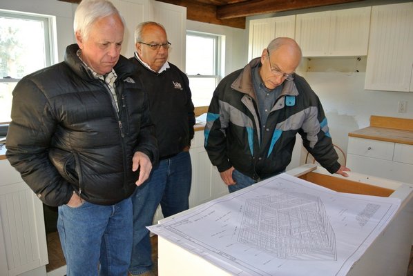 Larry Jones, builder Jim Zizzi and Bob Hirt look over the detailed plans for an East Hampton restoration project.