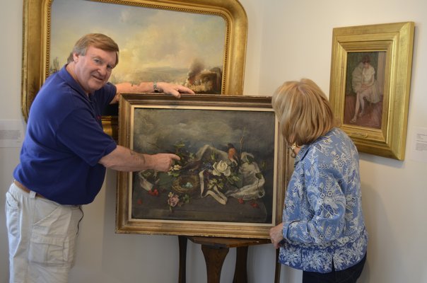 A painting is evaluated by Terry Wallace of the Wallace Gallery. BY ERIN MCKINLEY