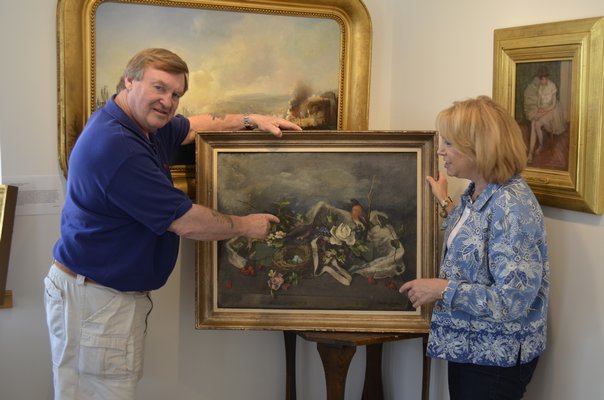 A painting is evaluated by Terry Wallace of the Wallace Gallery. BY ERIN MCKINLEY