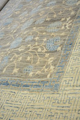 A rug with a Persian design with a Boujaran modern twist features a pomegranate motif, which is symbolic of truth and fertility in Samarkand, Uzbekistan, in natural wool colors and indigo vegetable dye. JD ALLEN