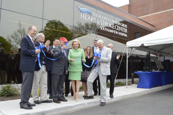 Joined by hospital and local officials, Audrey Gruss, center, cuts a ribbon at an opening ceremony for the Audrey and Martin Gruss Heart and Stroke Center at Southampton Hospital. ALYSSA MELILLO
